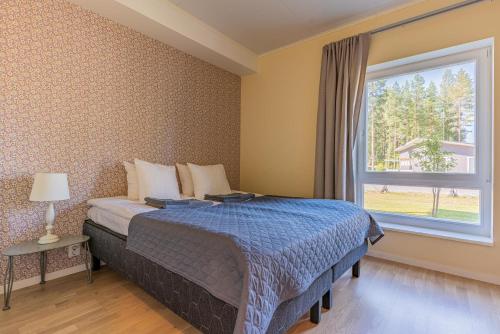 a bedroom with a bed and a window at Saimaa Life Apartments in Imatra