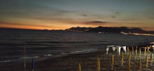 uma praia com cadeiras e o oceano ao pôr do sol em casa vacanze dei navigatori on the sea em Pontecagnano