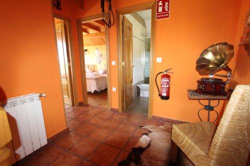a hallway with orange walls and a living room with a fire hydrant at Las Riendas casa rural in Muñeca