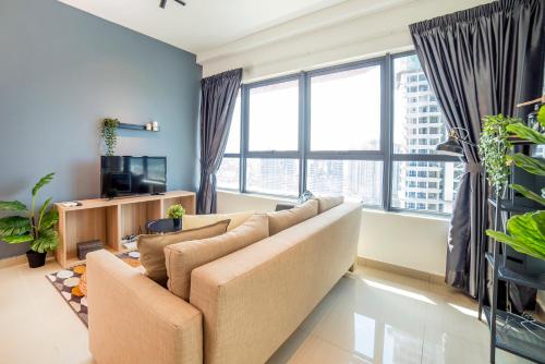 a living room with a couch and large windows at Arte Plus KLCC Designer Suites by Cobnb in Kuala Lumpur