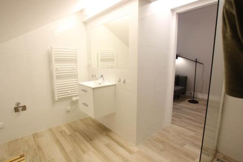 a white bathroom with a sink and a shower at Ośrodek Wypoczynkowy AKWA Marina in Nysa