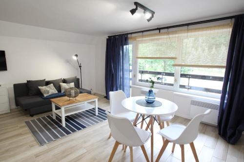 a living room with a couch and a table and chairs at Ośrodek Wypoczynkowy AKWA Marina in Nysa