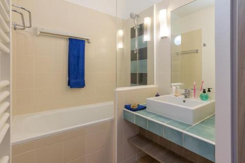 une salle de bain avec un lavabo, une baignoire et un miroir dans l'établissement Residence l Archipel, à Perros-Guirec