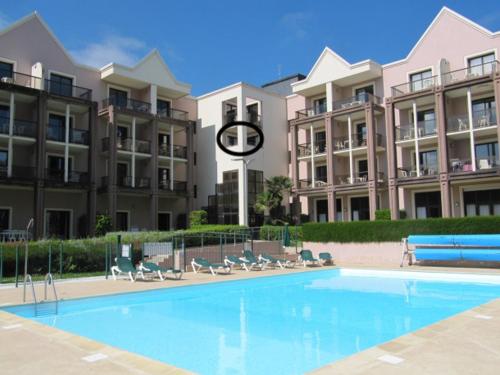 une piscine en face d'un grand bâtiment dans l'établissement Residence l Archipel, à Perros-Guirec