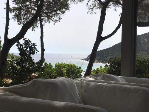 a couch in a room with a view of the ocean at Villa Sardinia Seaview&SPApool in Villasimius