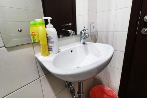 a white sink in a bathroom next to a mirror at Oliver's Guest House in Tangerang