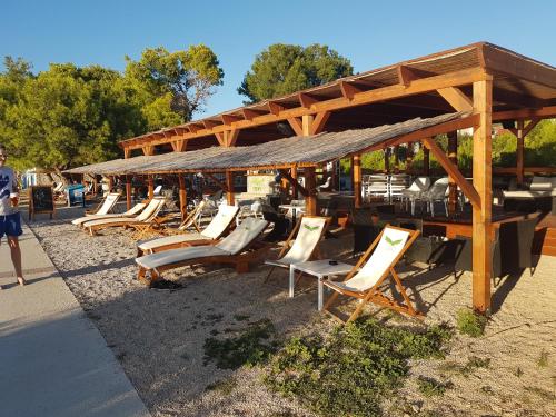a group of lounge chairs sitting on a beach at Apartmani Manzoni in Punat