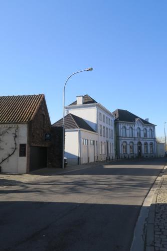 an empty street with white buildings and a street light at B&B / Studio De Druivelaar in hartje Kluisbergen (Berchem) in Kluisbergen