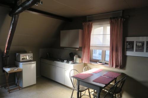 a kitchen with a table and a table and a window at B&B / Studio De Druivelaar in hartje Kluisbergen (Berchem) in Kluisbergen