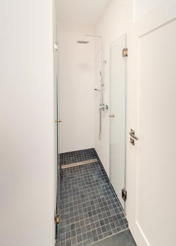 a bathroom with a shower and a tiled floor at Casa Del Sole in Alba Iulia