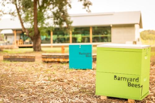 a green trash can sitting in front of a building at Barn Hives Yallingup in Yallingup
