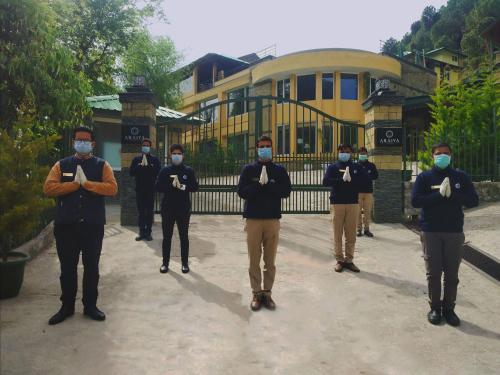 a group of people wearing masks standing in front of a gate at Araiya Palampur in Pālampur