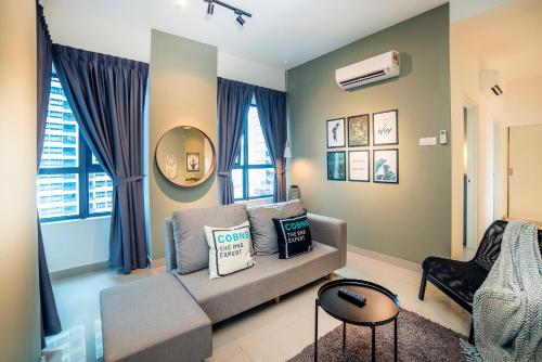 a living room with a couch and a chair at Arte Plus KLCC Designer Suites by Cobnb in Kuala Lumpur