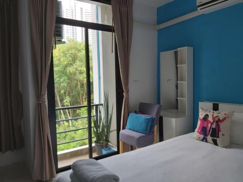 a bedroom with a bed and a large window at Baan der Bruyn SHA in Jomtien Beach