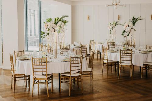 Pokój ze stołami i krzesłami z białymi obrusami w obiekcie Hotel Albatros w mieście Przemyśl