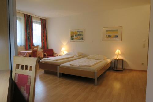 a hotel room with two beds and a chair at Appartement Mosser in Villach