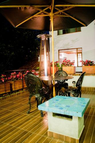 a table and chairs and an umbrella on a patio at Hotel Casona Usaquen in Bogotá