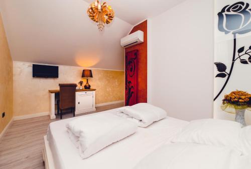 a bedroom with two white beds and a desk at Casa Del Sole in Alba Iulia