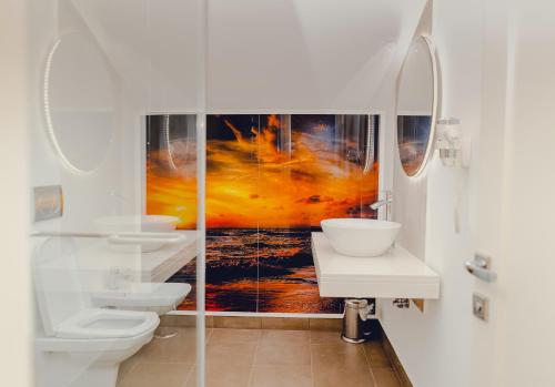 a bathroom with two toilets and a painting on the wall at Casa Del Sole in Alba Iulia