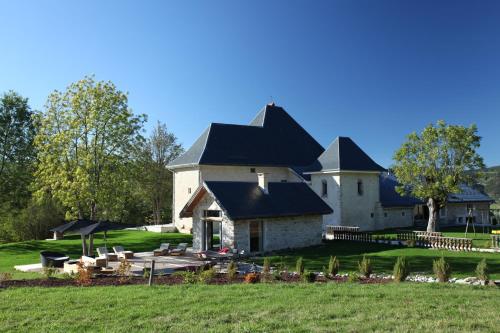 duży biały budynek z czarnym dachem w obiekcie L'appart du chateau des Girards w mieście Lans-en-Vercors