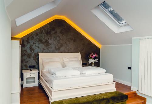 a bedroom with a white bed with a wall at Casa Del Sole in Alba Iulia