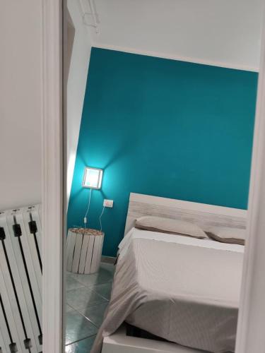 a bedroom with a blue wall and a bed at B&B Mediterranea in Meta