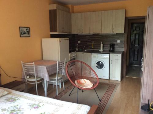 eine Küche mit einem Tisch und Stühlen sowie einem Kühlschrank in der Unterkunft Marina Studio in Burgas City