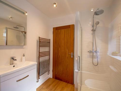 a bathroom with a shower and a sink and a mirror at 'Sea Breeze' Dorset dream holiday home in Poole