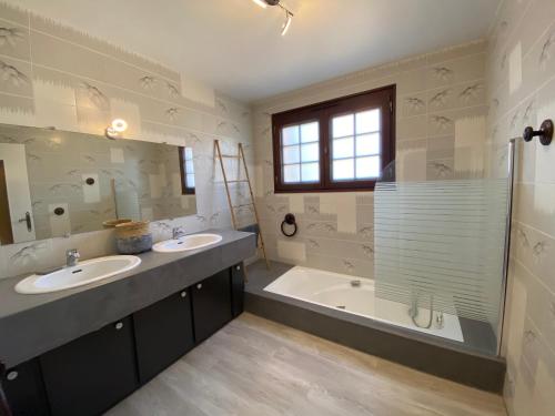 a bathroom with two sinks and a tub and a shower at GITE LAVANDE avec piscine privée CLASSÉ 4 Étoiles in Lagorce