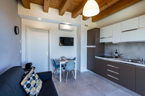 a kitchen with a couch and a table in a room at Casa Tina Holiday Home in Diano dʼAlba