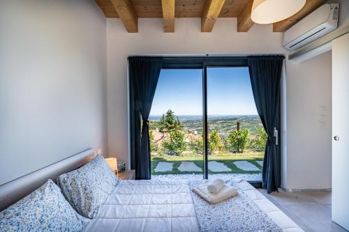 a bedroom with a bed and a large window at Casa Tina Holiday Home in Diano dʼAlba