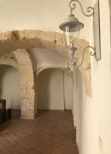 a room with a light on the wall and an archway at Domo Antiga Guest Rooms in Sorso