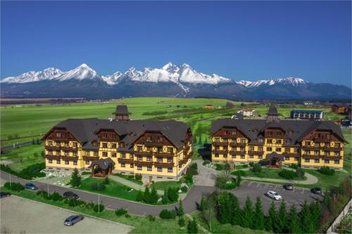 an aerial view of a large building with mountains in the background at Apartmány DeLuxe Lomnica in Veľká Lomnica