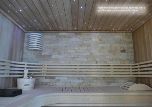 a room with a stone wall and a bench at Hotel Monte Cristo in Hoeselt