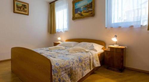 a bedroom with a bed with two lamps on it at Mali Marino 1 in Selce