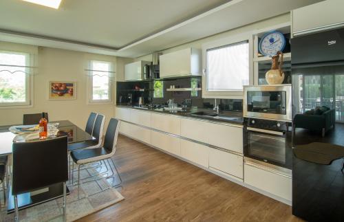 a kitchen with a table and a clock on the wall at CRESCENT TWINS- BLUE VİLLA in Dalyan