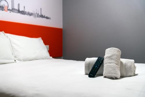 a bed with two towels and a remote control on it at easyHotel Croydon in Croydon