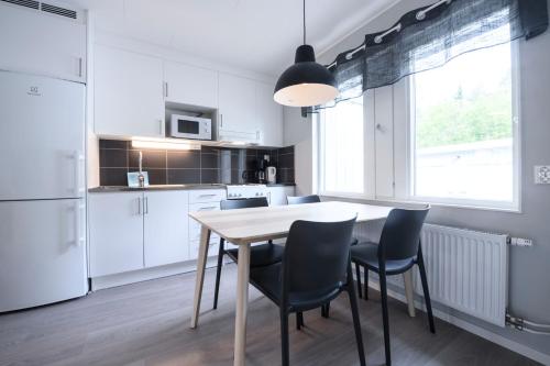 厄斯特松德的住宿－Östersunds Camping，白色的厨房配有桌椅