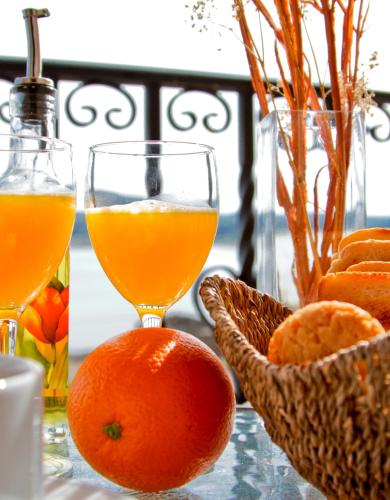 a glass of orange juice and a bowl of oranges on a table at Hotel Rural Salvatierra in Salvatierra de Tormes