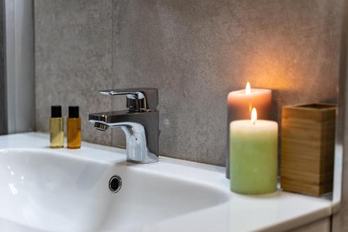 a bathroom sink with a candle and a faucet at Casa Tina Holiday Home in Diano dʼAlba