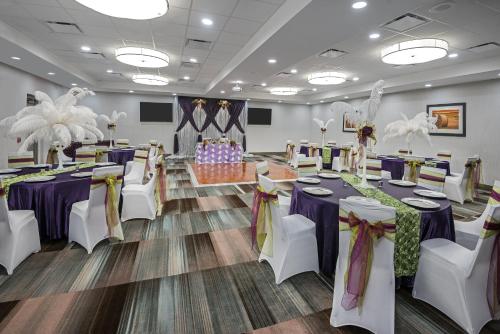 a banquet hall with purple tables and white chairs at Holiday Inn - Beaumont East-Medical Ctr Area by IHG in Beaumont