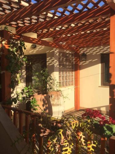 a patio with potted plants and a wooden pergola at Cosy Country Villa in Pappayiannádhes