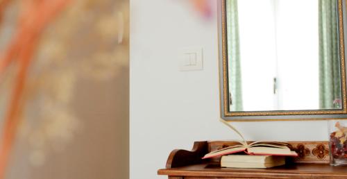 an open book on a table next to a mirror at Hotel Rural Salvatierra in Salvatierra de Tormes