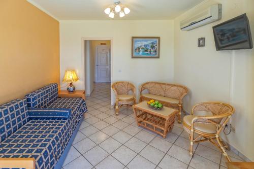 a living room with a couch and chairs and a table at Garbis Villas & Apartments in Lourdhata