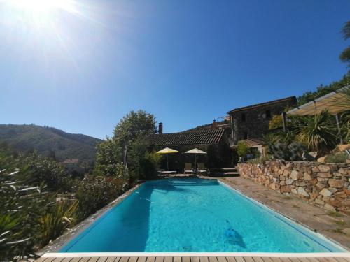 a swimming pool in front of a house at La Magnanerie de Camias in Saint-André-de-Majencoules