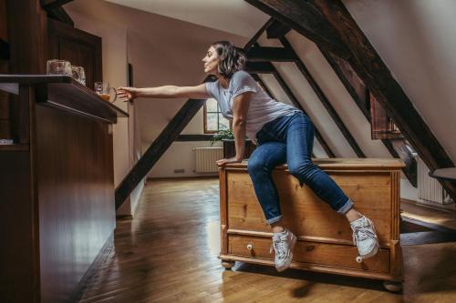 a woman sitting on top of a wooden bench at Residence Thunovska in Prague