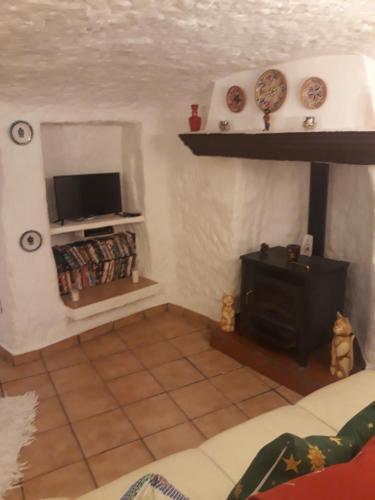 a living room with a tv and a fireplace at The Welcome Cave in Freila