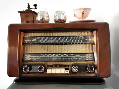 an old radio sitting on top of a table at Le petit Monrepos avec jacuzzi nordique in Bielle