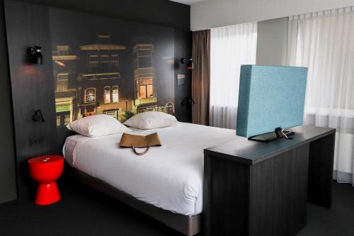 a bedroom with a large white bed with a blue wall at Mercure Hotel Tilburg Centrum in Tilburg