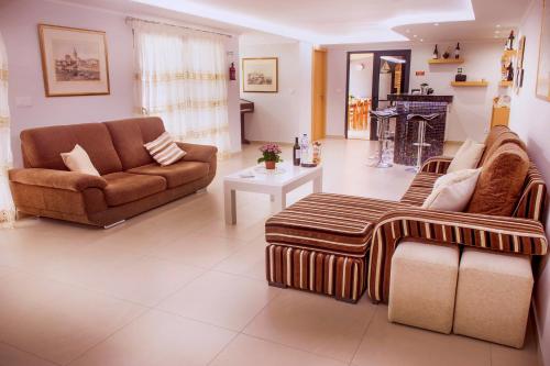 a living room with two couches and a fireplace at Barreiros House in Funchal